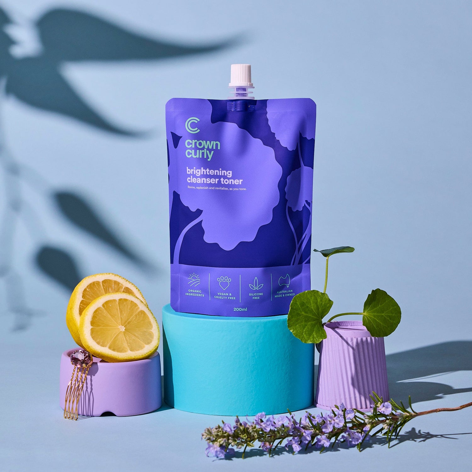Purple skincare product packaging with lemons and a plant on a blue background